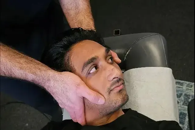 Hands cradling a patient's head during cervical work
